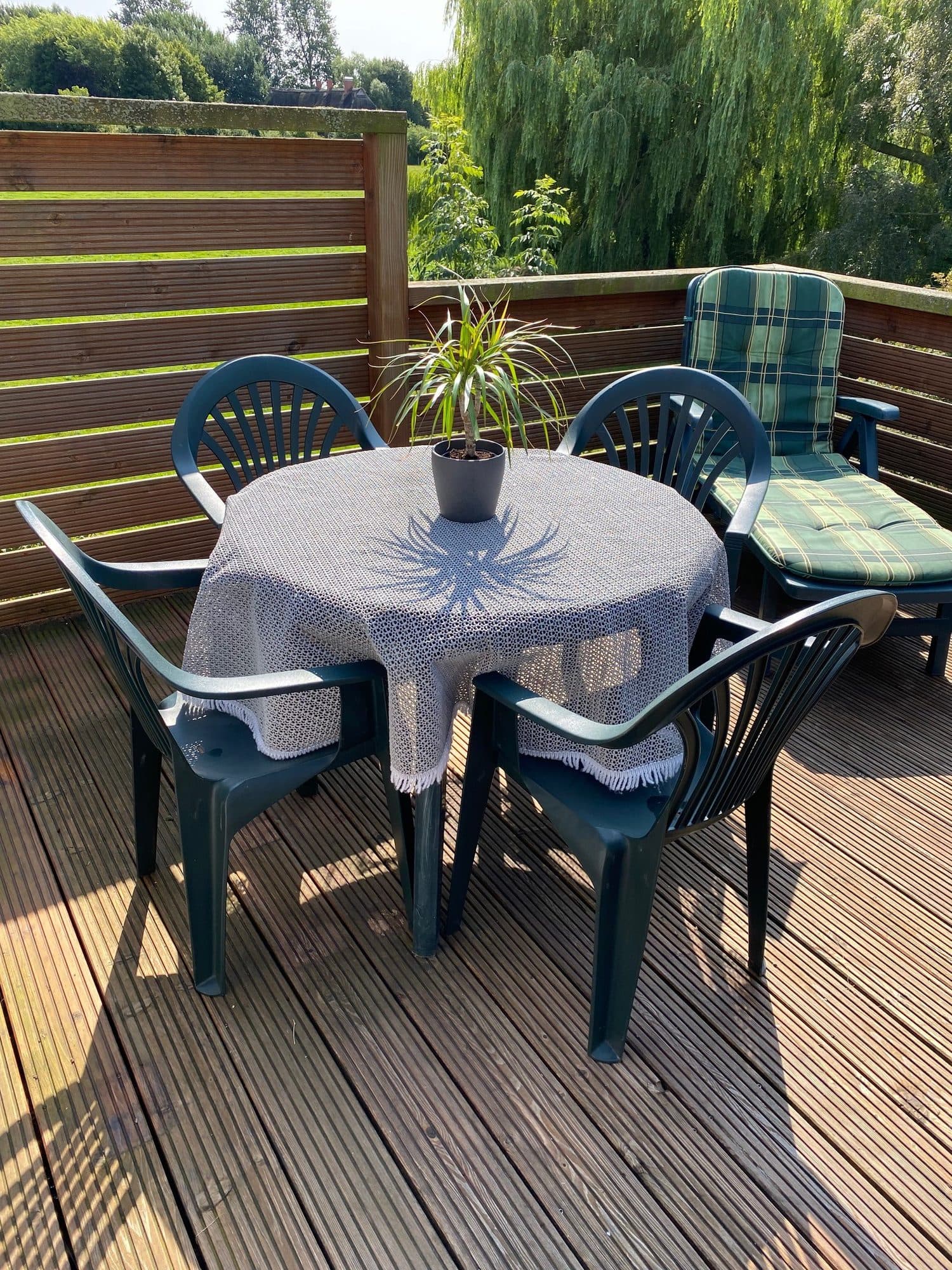 Terrasse mit gedecktem Gartentisch und Blick ins Grüne