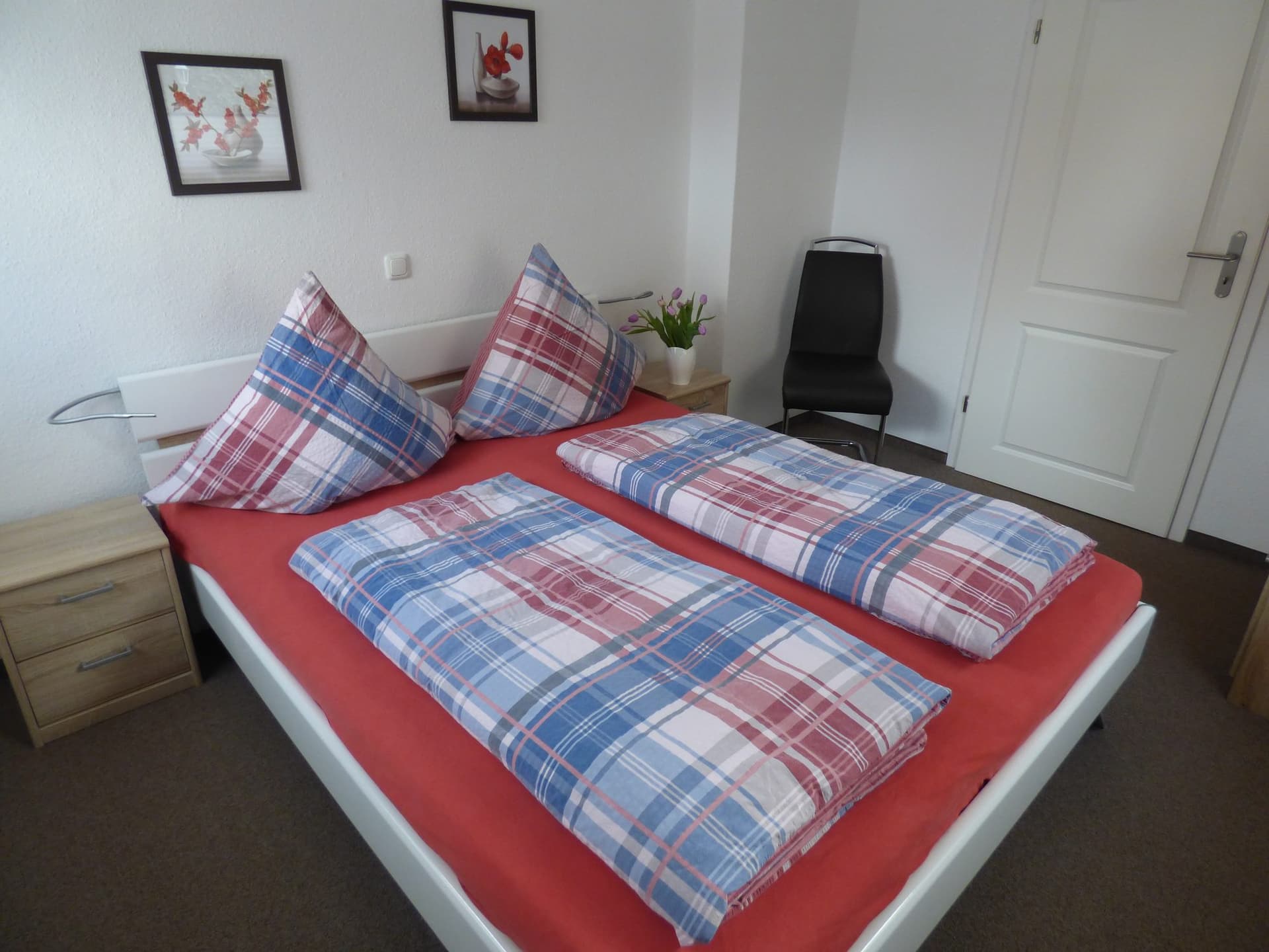 Zweites Schlafzimmer mit rot-blau karierter Bettwäsche